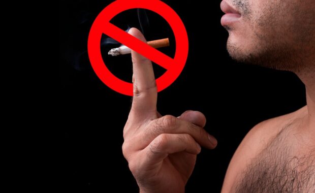 man holding a cigarette with two fingers and a cancel symbol layered over it