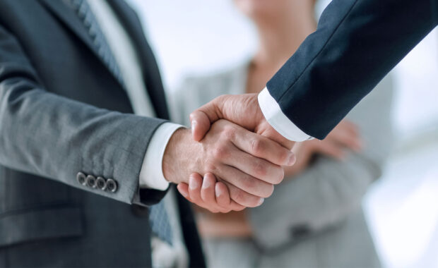 a small business owner shaking hands with a government contract consultant