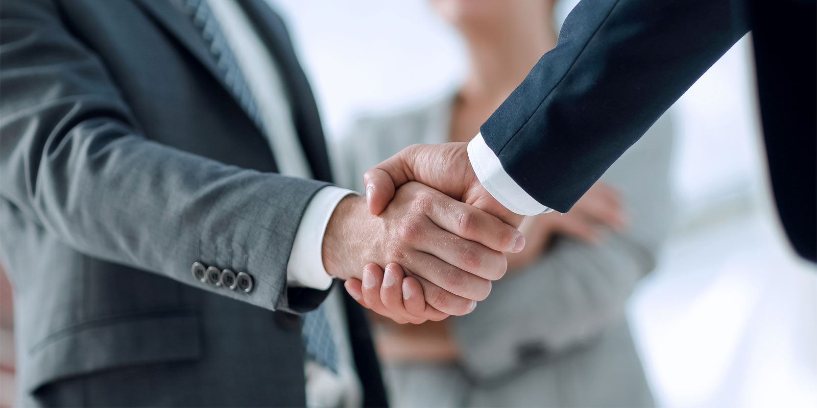 a small business owner shaking hands with a government contract consultant